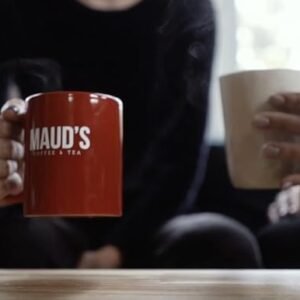two people drinking mauds Coffee in a Mauds Coffee cup