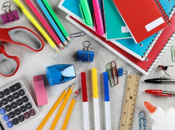 Promotional graphic featuring assorted back-to-school supplies including notebooks, pencils, pens, markers, folders, and classroom essentials.