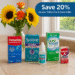 A summer-themed photograph of eye care products arranged on a beige tiled counter. The scene includes a bouquet of bright yellow sunflowers in a vase, surrounded by a selection of popular eye drops and contact lens solutions, such as Pataday, Systane, Clear Care, and Genteal.