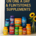 Assorted bottles of One A Day and Flintstones vitamins on colorful background.