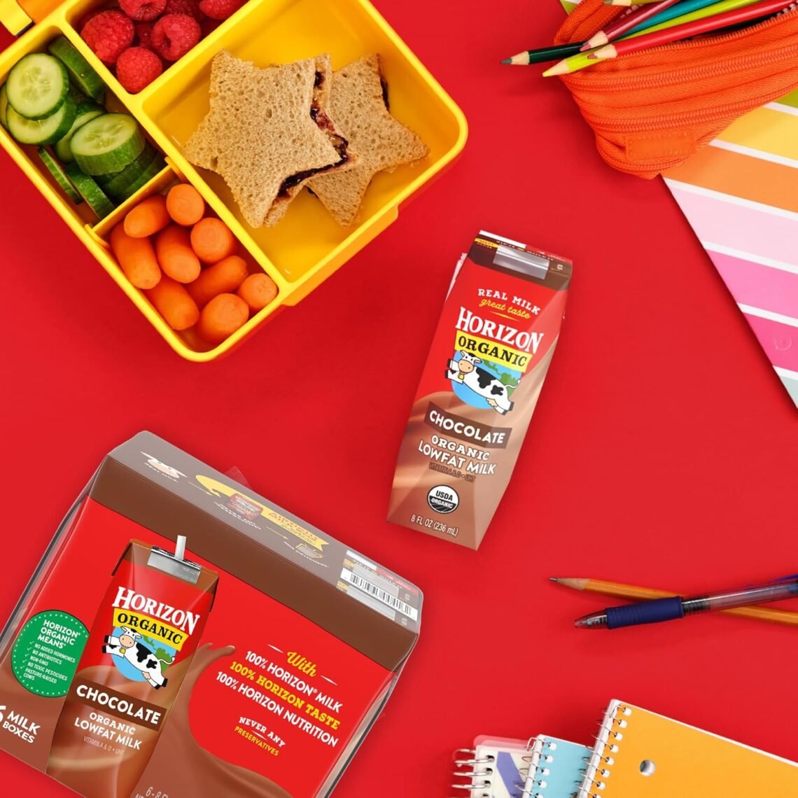 Person handing Horizon Organic shelf-stable chocolate milk boxes to happy kids outdoors in a cozy fall scene