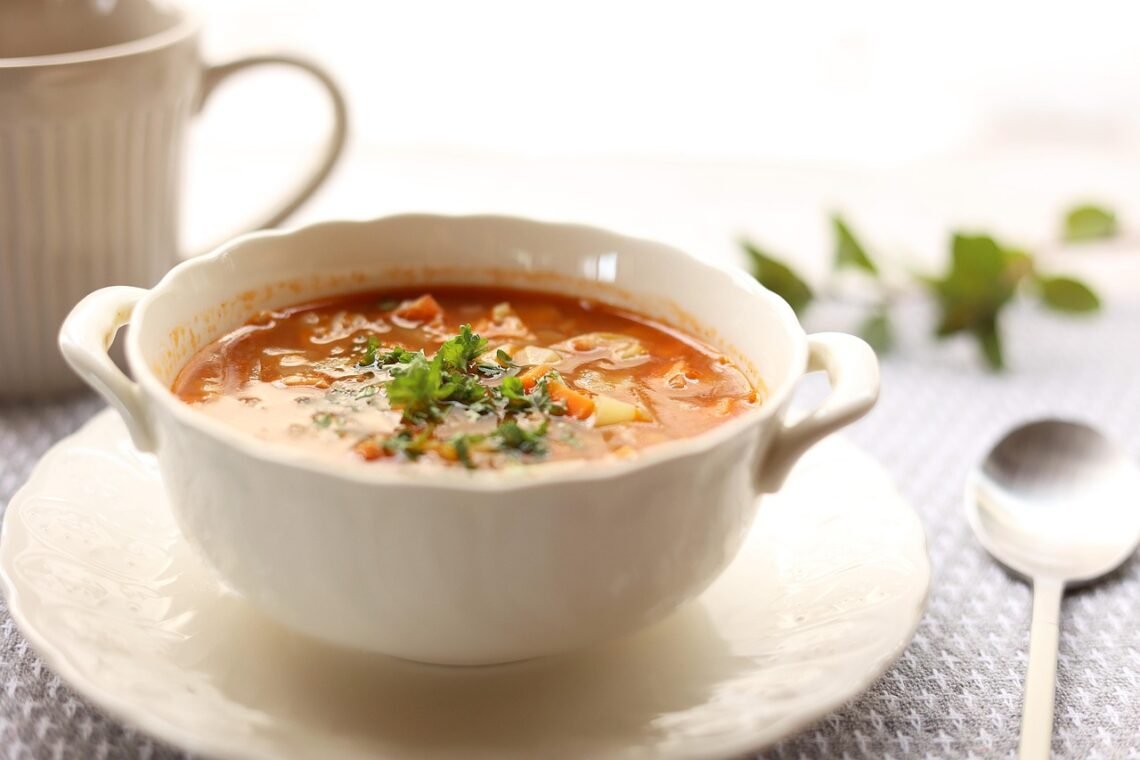 Close-up of a bowl of prepared soup with visible vegetables in broth.