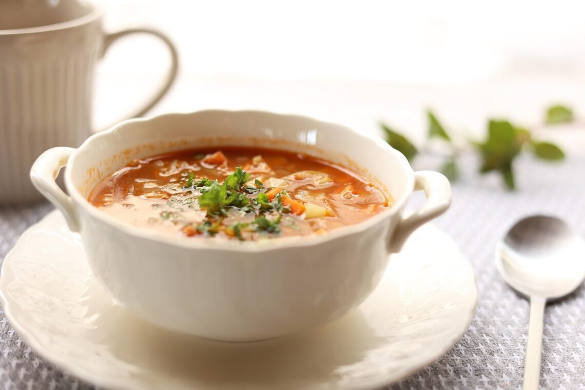 Hearty vegetable soup and minestrone soup in bowls representing chunky soup meal options.