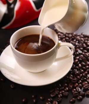 A warm, inviting image featuring coffee beans, brewed coffee, and cozy morning elements with soft lighting