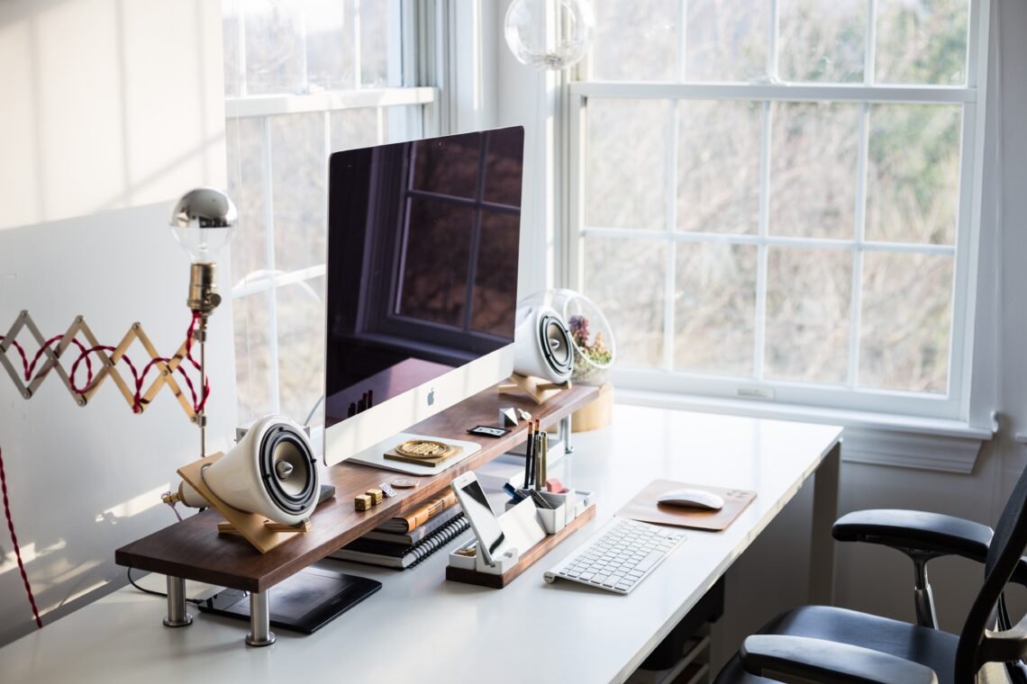 A clean keyboard workspace under a soft blue sky-inspired background with light cloud textures and delicate cherry blossom accents, creating an airy and serene spring office setting.