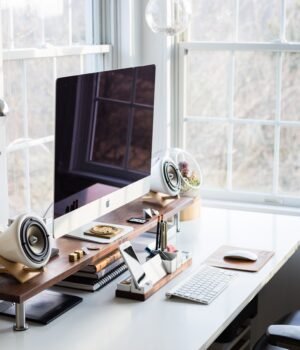 A clean keyboard workspace under a soft blue sky-inspired background with light cloud textures and delicate cherry blossom accents, creating an airy and serene spring office setting.