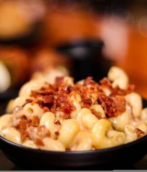 macaroni and cheese topped with bacon bits in a bowl