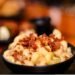 macaroni and cheese topped with bacon bits in a bowl