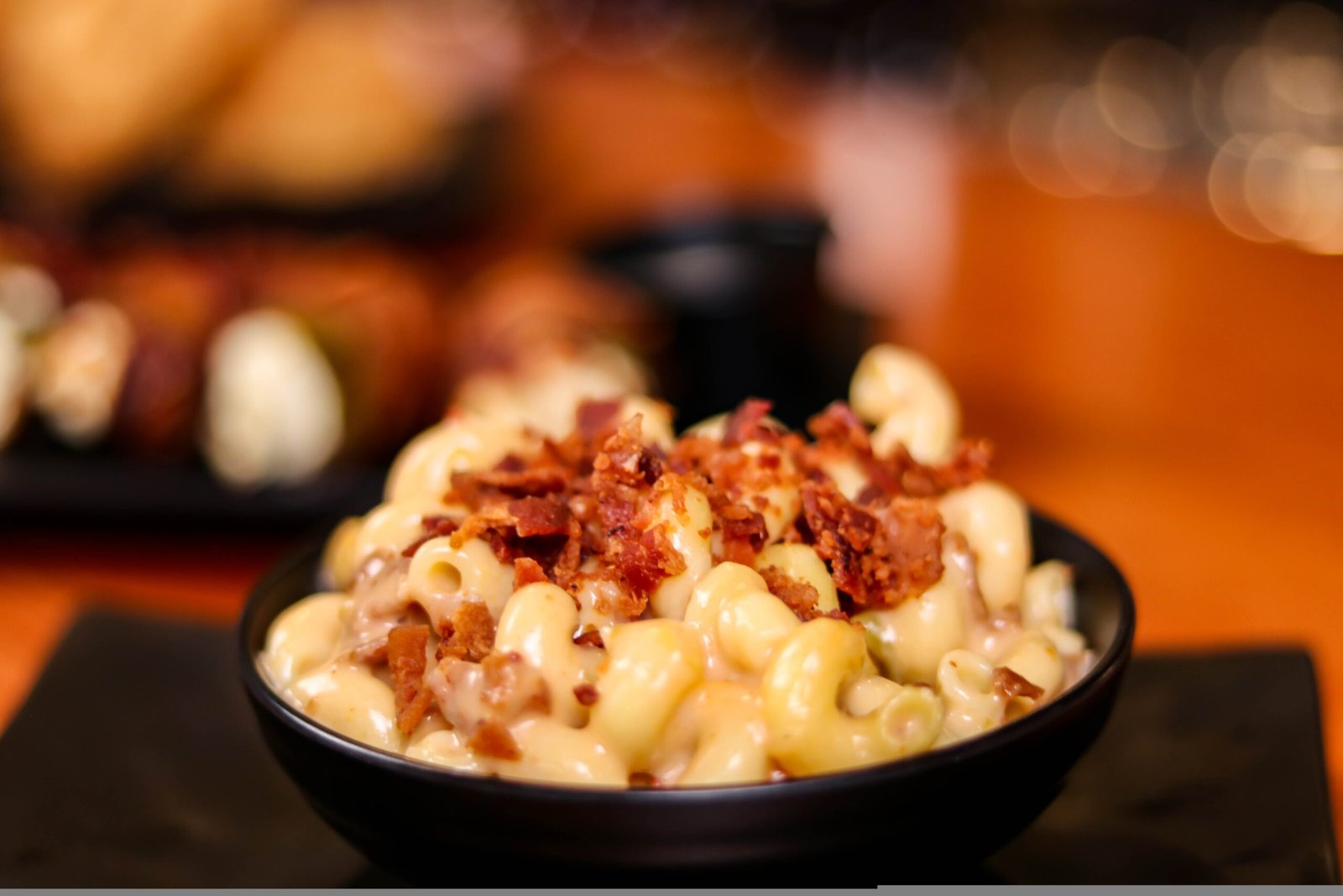 macaroni and cheese topped with bacon bits in a bowl