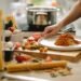 A close-up of spaghetti pasta in a kitchen setting with a soft blue sky-inspired background, light cloud textures, and delicate cherry blossom accents creating an airy spring cooking scene.