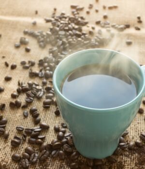 Fresh Roasted Coffee products displayed beside coffee mugs and roasted coffee beans during a featured coffee savings promotion.