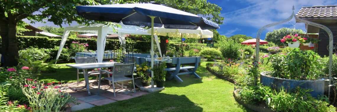 A bright spring and summer-themed snack setup featuring beverages, chips, cereals, and pantry foods with soft blue skies, light clouds, and subtle cherry blossom accents for a cheerful seasonal feel