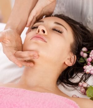 A bright spring-inspired wellness setup featuring skincare and beauty products with soft blue skies, light clouds, and subtle cherry blossom accents for a calm seasonal feel