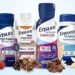 Promotional graphic featuring assorted Ensure ready-to-drink nutrition shakes in multiple flavors and protein formulas.