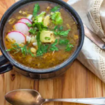 Bowl of chicken verde soup with bright green salsa verde broth and toppings.