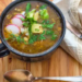 Bowl of chicken verde soup with bright green salsa verde broth and toppings.