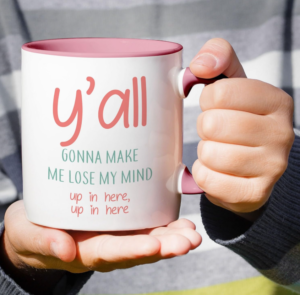 Funny white ceramic mug with a pink handle and interior featuring the phrase “You All Y’all Gonna Make Me Lose My Mind.”