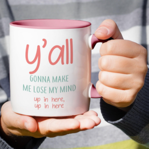 Funny white ceramic mug with a pink handle and interior featuring the phrase “You All Y’all Gonna Make Me Lose My Mind.”