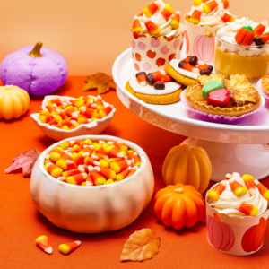 Brach's candy corn packages displayed together with pieces of classic candy corn.